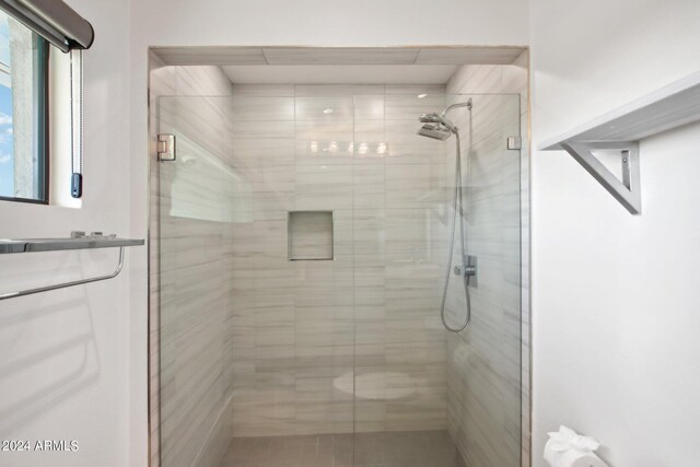 bathroom featuring a shower with door and vanity