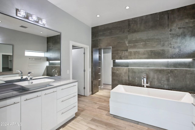 bathroom featuring vanity, hardwood / wood-style floors, and a bathtub