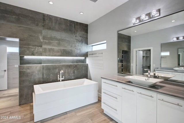 bathroom with vanity, a tub, and hardwood / wood-style floors