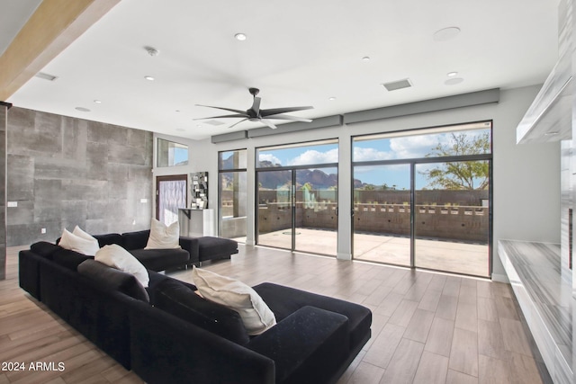 living room featuring light hardwood / wood-style flooring and ceiling fan