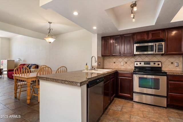 4015 N 78th St Unit 135, Scottsdale, AZ 85251 - kitchen featuring stainless steel appliances, a peninsula, backsplash, stone tile floors, and recessed lighting
