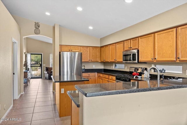 4657 E Matt Dillon Trl, Cave Creek, AZ 85331 - kitchen featuring appliances with stainless steel finishes, vaulted ceiling, a kitchen island, light tile patterned flooring, and a peninsula