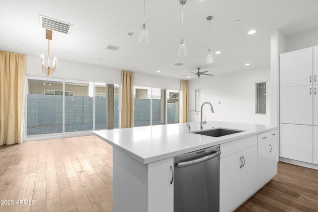 kitchen with an island with sink, sink, stainless steel dishwasher, and white cabinets