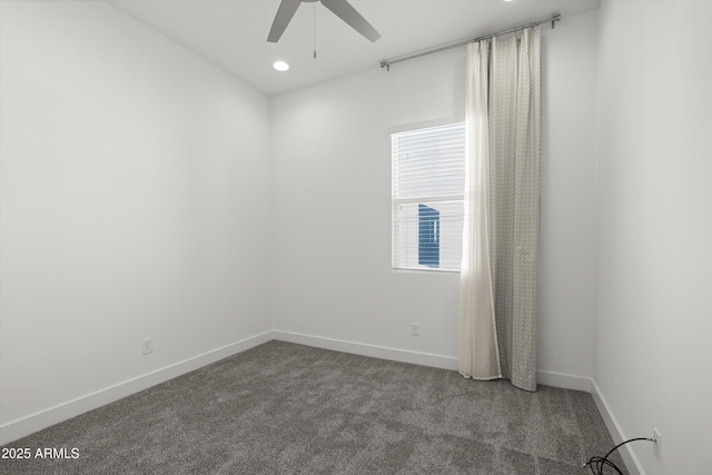 unfurnished room with ceiling fan and dark carpet