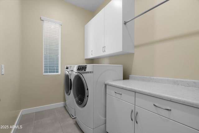 clothes washing area featuring cabinets, washer and clothes dryer, and light tile patterned floors