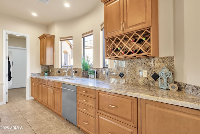 kitchen with light stone counters, sink, light tile patterned floors, and tasteful backsplash