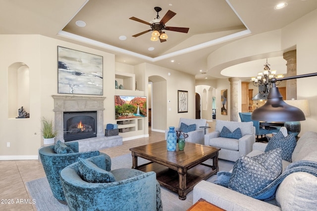 living room with lofted ceiling, light tile patterned floors, ceiling fan, and a tray ceiling