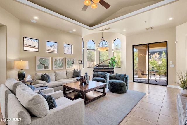 tiled living room with ceiling fan and high vaulted ceiling