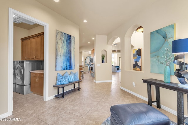 hall with separate washer and dryer and light tile patterned floors