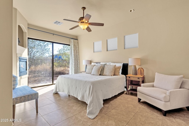 bedroom featuring a fireplace, access to outside, ceiling fan, and light tile patterned flooring