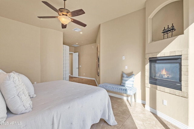 tiled bedroom with a tile fireplace and ceiling fan