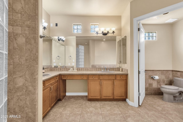 bathroom featuring tile patterned flooring, vanity, tile walls, and toilet