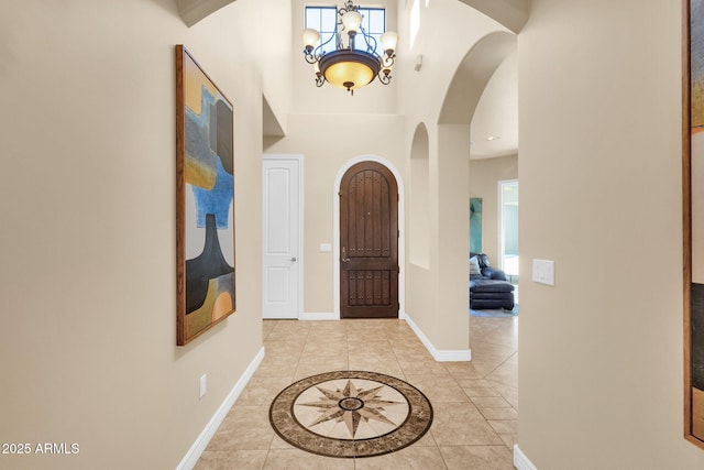 tiled foyer featuring a notable chandelier