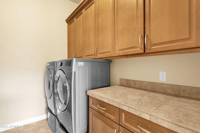 washroom featuring separate washer and dryer, cabinets, and light tile patterned flooring