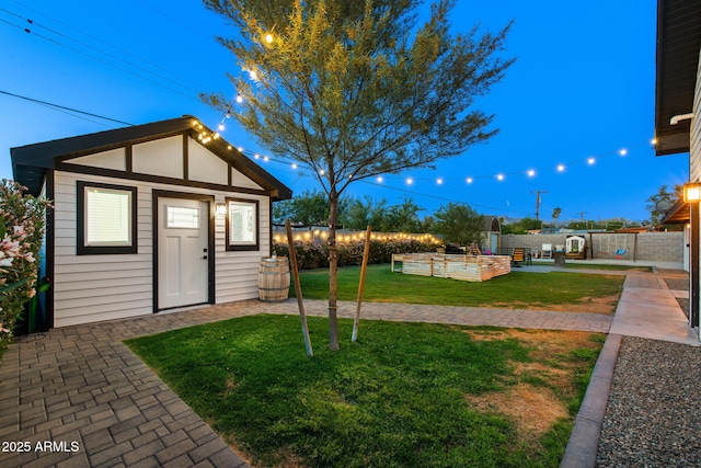 view of yard with fence, an outbuilding, and a patio area