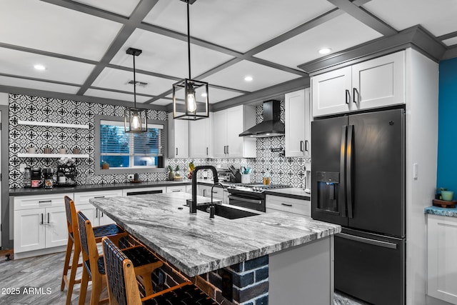 kitchen featuring open shelves, black fridge, wall chimney exhaust hood, visible vents, and stainless steel gas stove