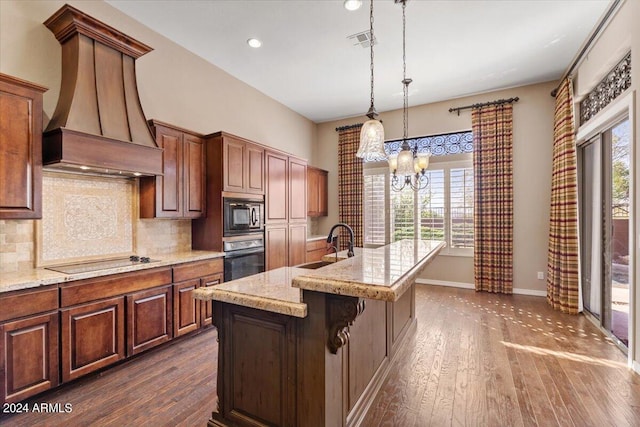 kitchen with a center island with sink, a chandelier, black appliances, dark wood-type flooring, and sink