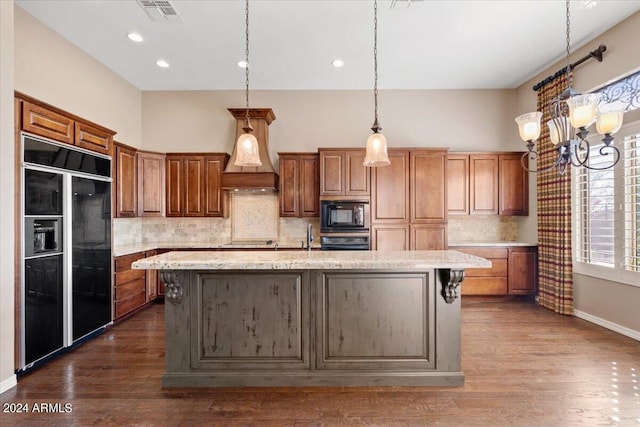 kitchen with light stone countertops, black appliances, an island with sink, and dark hardwood / wood-style floors