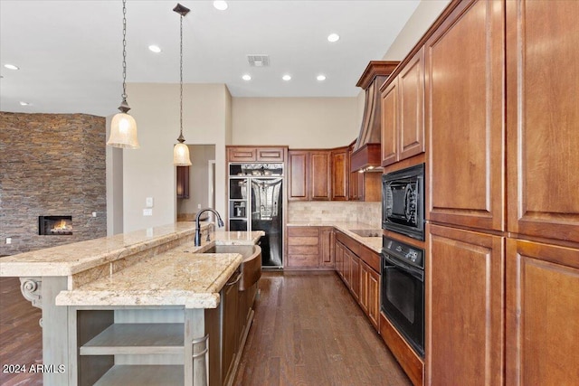 kitchen with black appliances, sink, a spacious island, pendant lighting, and dark hardwood / wood-style floors