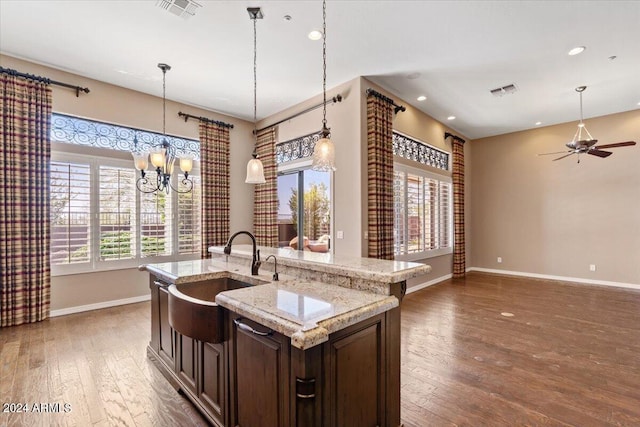 kitchen featuring dark wood-type flooring, sink, plenty of natural light, and a kitchen island with sink