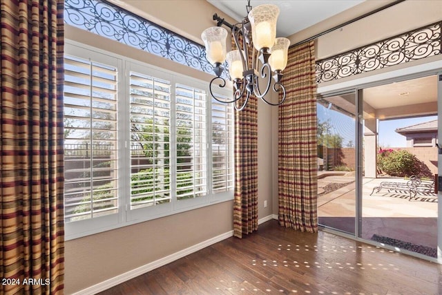 unfurnished dining area featuring hardwood / wood-style floors and a chandelier