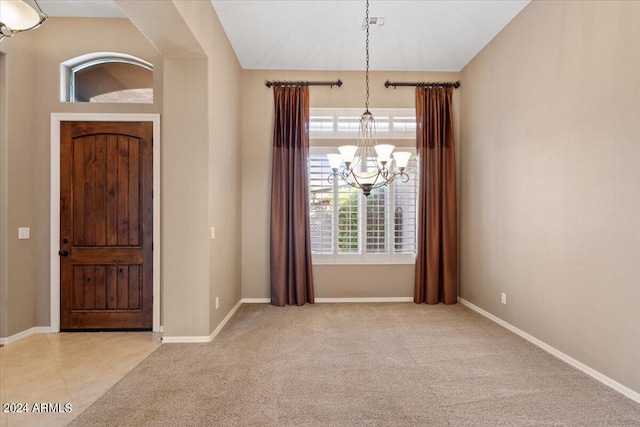 foyer featuring a chandelier and light carpet