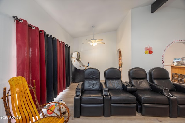 cinema featuring ceiling fan, light hardwood / wood-style floors, and lofted ceiling with beams