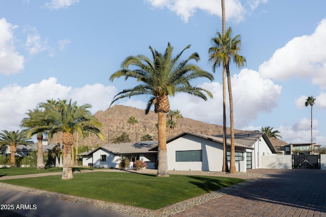 view of front of property with a mountain view and a front lawn