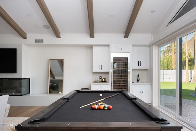 game room with pool table, beamed ceiling, and indoor wet bar