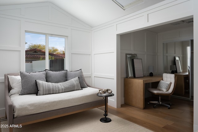 living area featuring vaulted ceiling and hardwood / wood-style floors