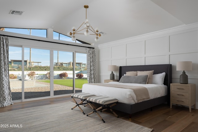 bedroom with a notable chandelier, wood-type flooring, vaulted ceiling, and access to outside