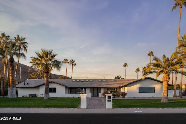 single story home featuring a lawn