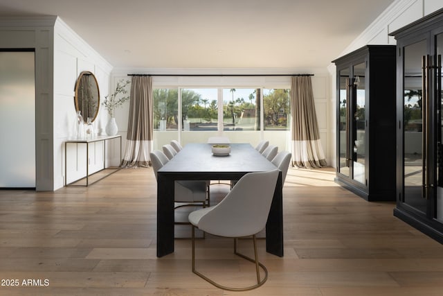 dining space with crown molding and wood-type flooring