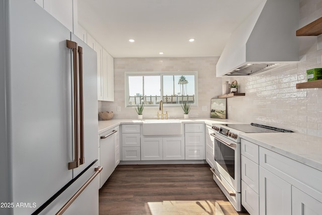 kitchen featuring sink, premium range hood, white cabinetry, premium appliances, and dark hardwood / wood-style flooring