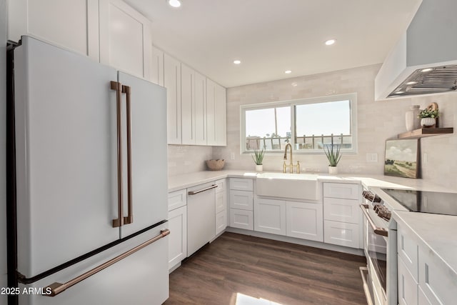 kitchen with dark hardwood / wood-style floors, white cabinetry, sink, custom range hood, and white appliances