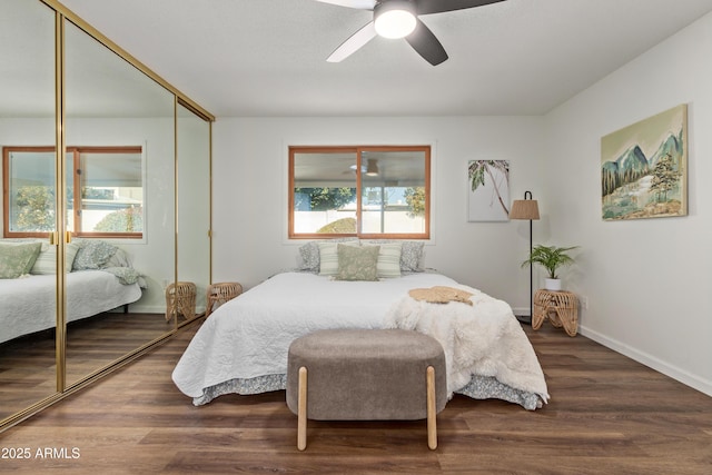 bedroom featuring dark wood-type flooring, ceiling fan, and a closet