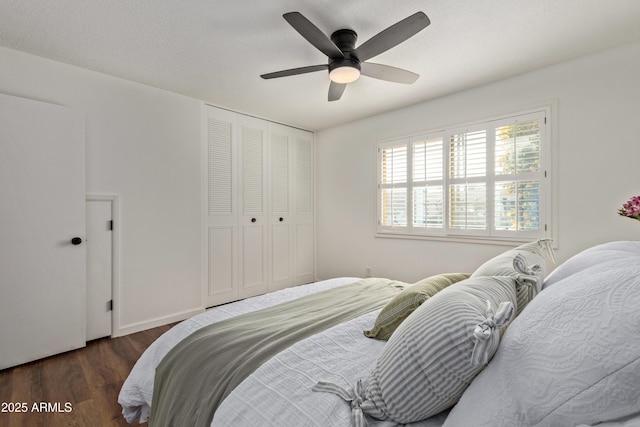 bedroom featuring ceiling fan, dark wood-type flooring, a textured ceiling, and a closet