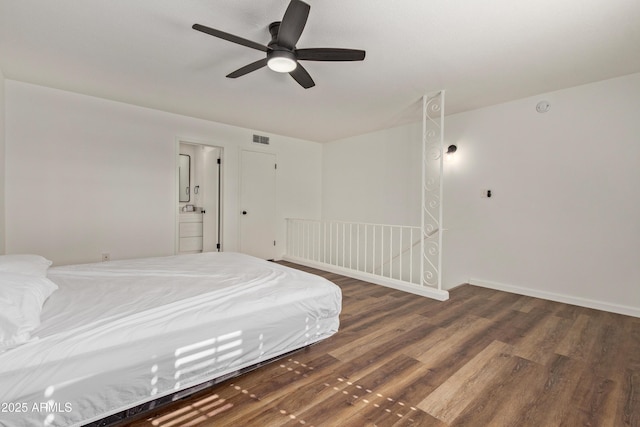 unfurnished bedroom featuring ceiling fan, ensuite bathroom, and dark hardwood / wood-style flooring