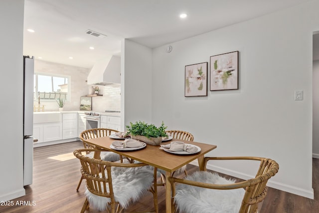 dining space with sink and hardwood / wood-style floors