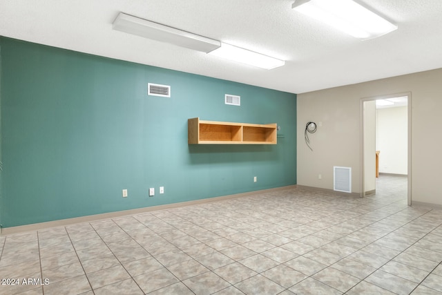 unfurnished room with a textured ceiling