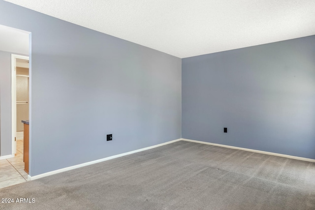 carpeted spare room featuring a textured ceiling