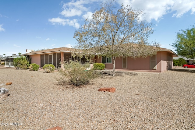 rear view of property featuring a sunroom