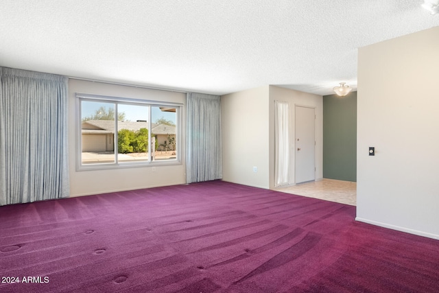 empty room featuring light carpet and a textured ceiling