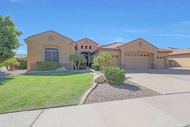 mediterranean / spanish house with a front yard and a garage