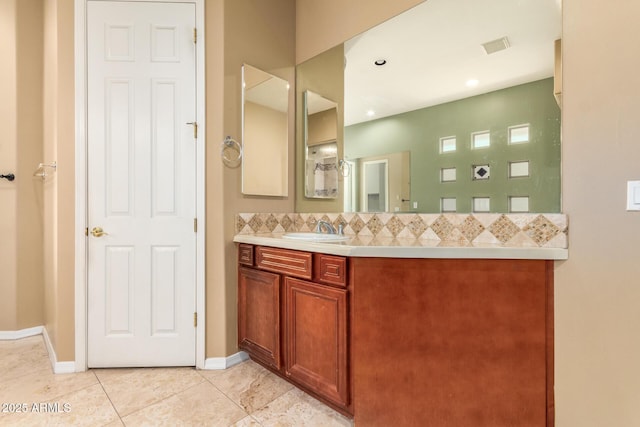bathroom featuring vanity, decorative backsplash, visible vents, baseboards, and tile patterned flooring