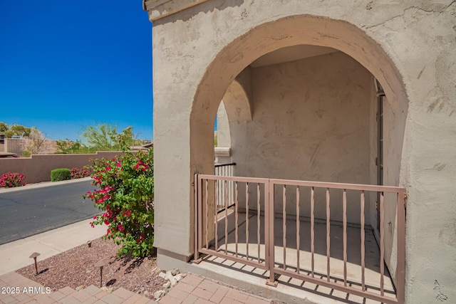 entrance to property with fence and stucco siding