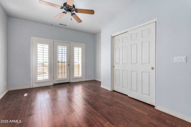 unfurnished bedroom with access to exterior, ceiling fan, dark wood-style flooring, baseboards, and visible vents