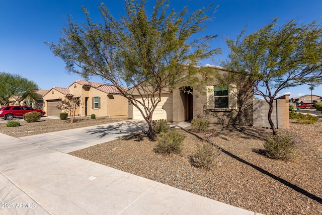 view of front facade with a garage, driveway, a tile roof, and stucco siding