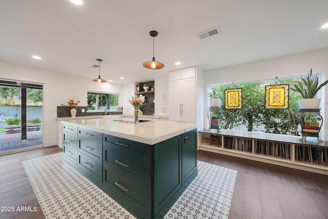 kitchen featuring visible vents, dark wood finished floors, a center island, white cabinetry, and green cabinets