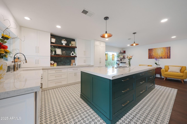 kitchen with open shelves, decorative backsplash, white cabinets, a sink, and green cabinetry